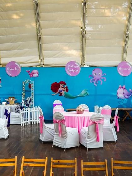 The indoor seating area for the mermaid party, with tables decorated in shades of purple and pink to create an under-the-sea feel.