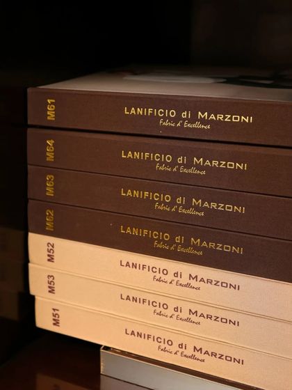 A stack of fabric books from Lanificio di Marzoni, another top-tier Italian fabric maker. We provide a wide choice of 'Fabric d'Excellence' for our clients.