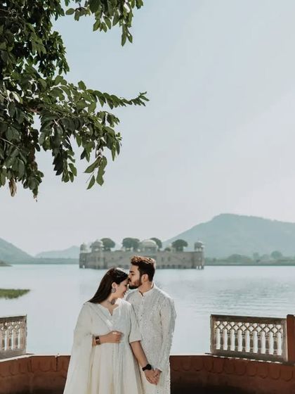 A gentle kiss on the forehead, framed by the lush greenery and the stunning view of Jal Mahal. This shot is all about quiet, tender romance.