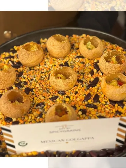 A fusion snack of Mexican Golgappa, presented on a bed of colorful lentils. This creative presentation highlights the unique blend of cultures in this delicious bite.