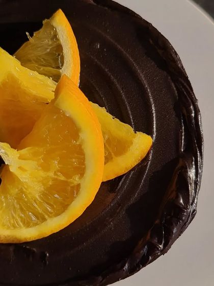 A close-up shot of the fresh mandarin orange slices on top of the rich chocolate ganache.