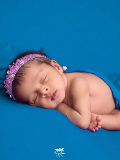 The classic tummy pose on a simple, bold blue backdrop. This allows us to capture all the sweet details, from their tiny lips to their curled fingers.
