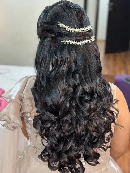 A gorgeous engagement hairstyle with soft, bouncy curls and delicate pearl hair accessories.