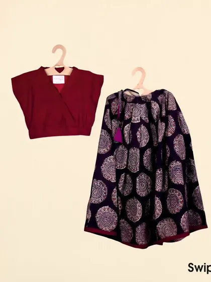A classic combination of a deep maroon crop top with a beautiful Kalamkari print ghagra. The earthy tones and traditional block print make this a timeless ethnic outfit for girls.