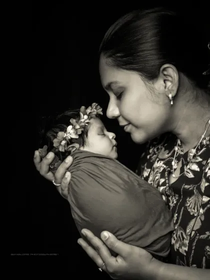 In her hands, she holds her whole world. This artistic black and white portrait emphasizes the deep, emotional bond between a mother and her child.