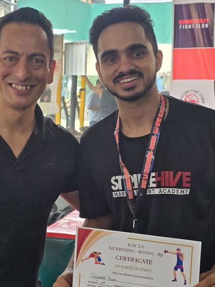 A student proudly receives his certificate of participation, a testament to his courage to step into the ring.