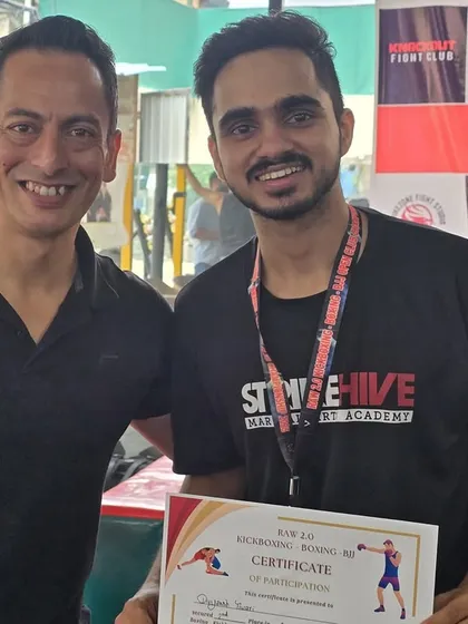 A student proudly receives his certificate of participation, a testament to his courage to step into the ring.