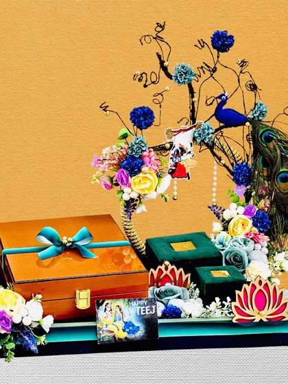 A truly unique Teej hamper featuring a miniature tree with a peacock, surrounded by gift boxes and flowers. This design is perfect for presenting jewelry or other small, precious gifts.