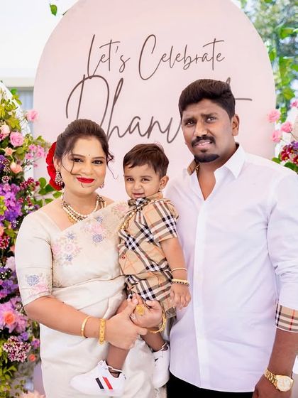 A beautiful family portrait. The floral decor provides a lush and joyful background, perfectly complementing the family's happy smiles as they celebrate their little one.