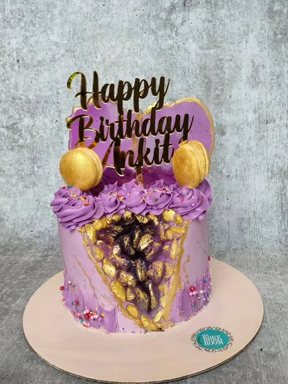 A stunning amethyst geode cake. The purple buttercream cake is cut away to reveal a sparkling crystal formation made of rock candy, creating a beautiful and unique design.