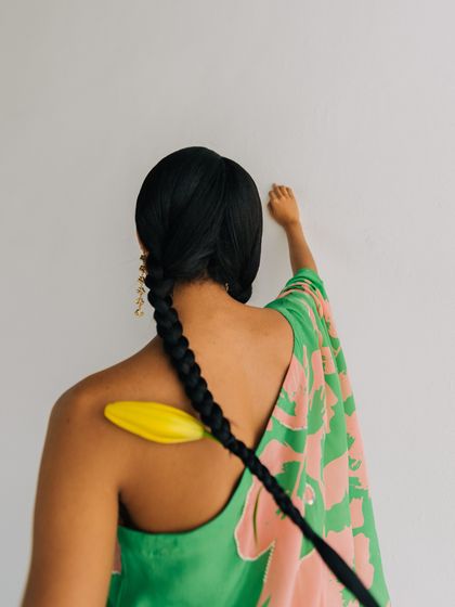 A creative detail from a shoot for Esha Arora. We incorporated a fresh Calla Lily into the model's braid, adding an organic and unexpected element to the styling.
