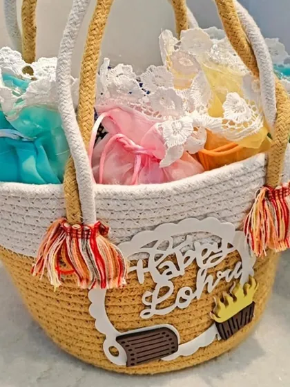 A yellow and white version of the Lohri hamper basket, filled with colorful potlis.