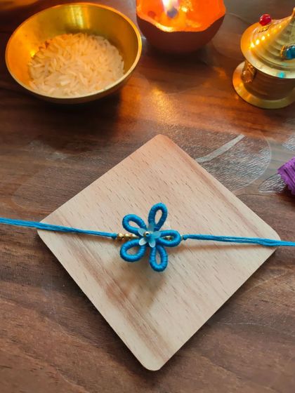 A lovely blue floral rakhi made with thread. This design is simple, elegant, and celebrates the spirit of Raksha Bandhan.