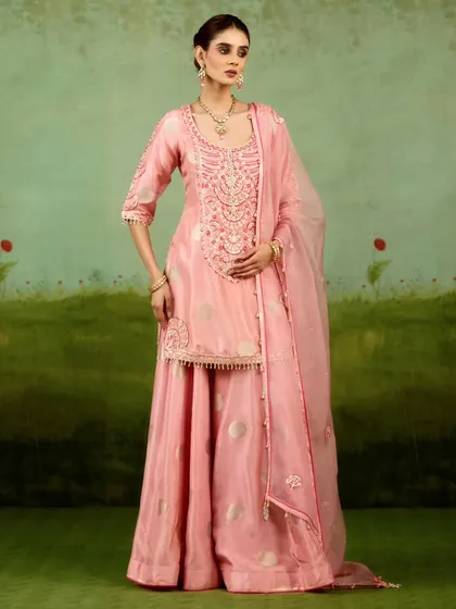 Playful yet refined, this soft pink sharara set brings modern ease to festive elegance. With its fluid lines, intricate zardozi work on the kurta, and hand-finished details, it is a perfect choice for a daytime celebration.