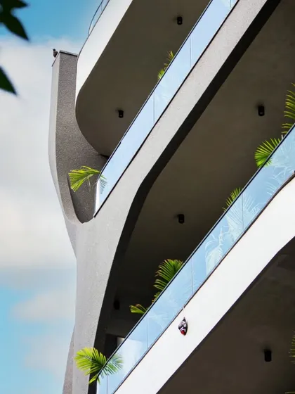 Looking up at the sweeping curves of the Lotus Villa's balconies. This angle emphasizes the fluid, upward movement of the design against the sky.