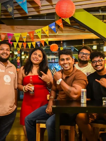 A group of friends posing for a picture, capturing the fun and festive atmosphere of the bar.