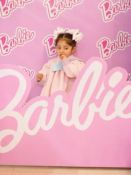 The adorable birthday girl posing inside the Barbie box photo booth. These are the fun, candid moments that make a party special.