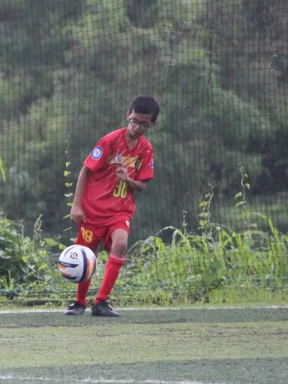 A young player practicing his ball-juggling skills during a break.