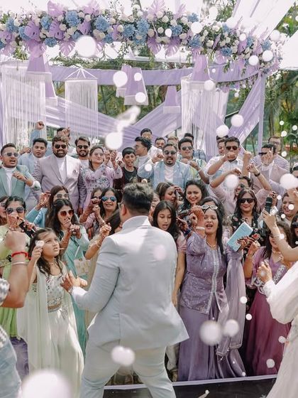 The entire wedding party erupts in a dance, surrounded by bubbles. This shot captures the collective joy and celebration of the day.