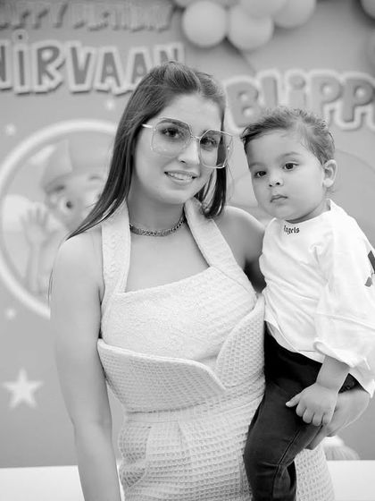 A classic mother and son portrait in black and white, set against the fun party backdrop. A timeless memory from his second birthday.