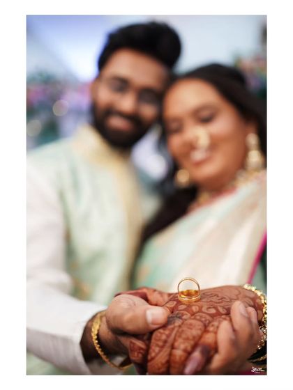 A classic ring shot, with the couple's happy faces blurred in the background, symbolizing their commitment.
