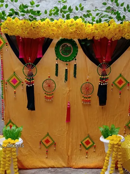 A closer look at the details of the traditional Haldi decor, including the green and red accents, tassel hangings, and decorative umbrellas.