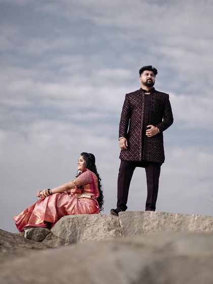 A wide shot from the same session, showing the couple against the vastness of the sky and rocks.
