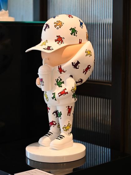 The full view of the Keith Haring "Kid Cup" sculpture on its pedestal, a perfect blend of pop art and street culture.