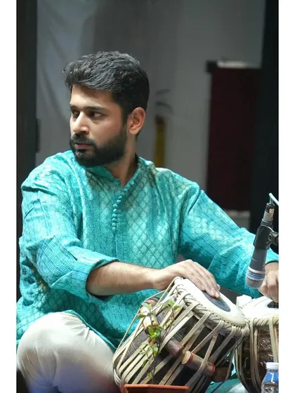 Looking towards the main artist, listening intently to their musical phrases.