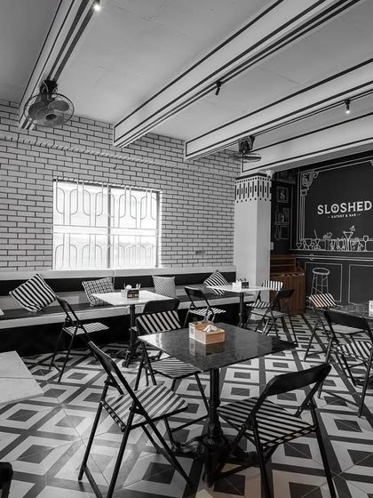 A wide shot of the sketch cafe, demonstrating how the concept extends throughout the entire space. The exposed ceiling beams are painted with black lines to further enhance the illustrative effect.