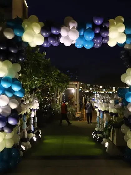 A grand balloon arch at the entrance of the party. The mix of dark blue, light blue, white, and lime green balloons created a festive and inviting walkway for guests.