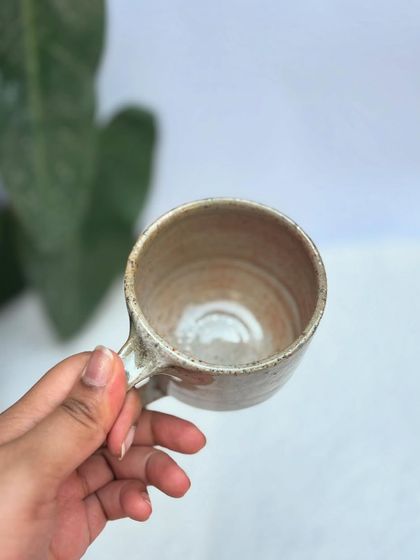 A look inside the Shino cup, showing the smooth, glossy interior and the throwing rings that mark it as handmade.