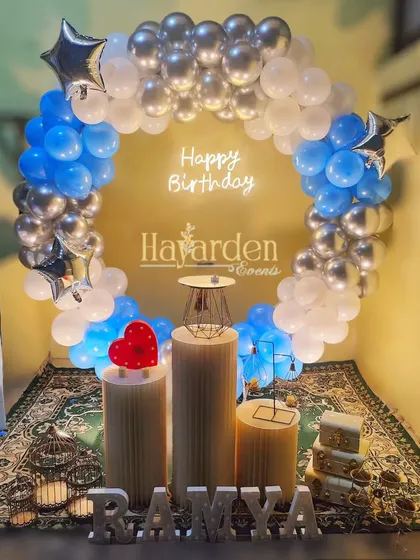 A blue and silver balloon ring with a 'Happy Birthday' neon sign, perfect for a modern and stylish party.
