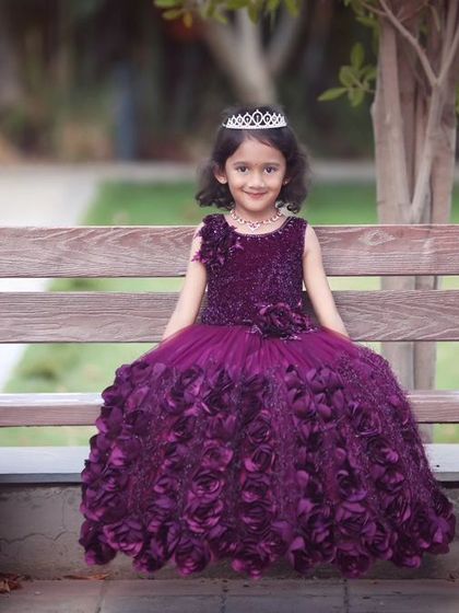 A regal portrait of the birthday girl sitting on a bench in her gorgeous purple gown, looking like a true princess.