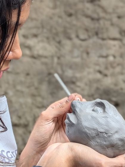 Hand-building isn't just for pots and mugs. This student is sculpting a small, expressive face, showing how you can use clay to create unique art pieces.