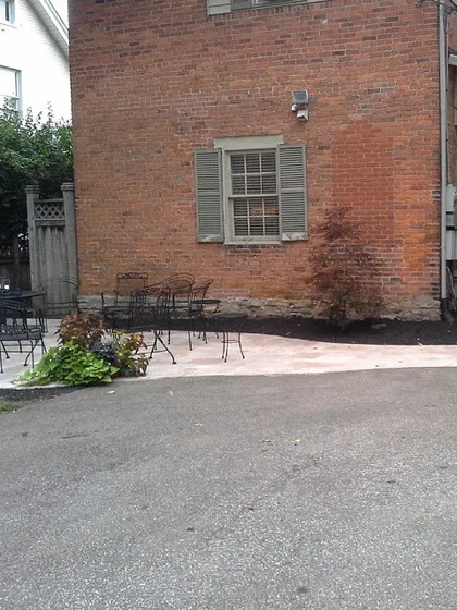 Here is the finished patio next to the brick building. It replaced an old, uneven surface and provides a stable and attractive outdoor space.
