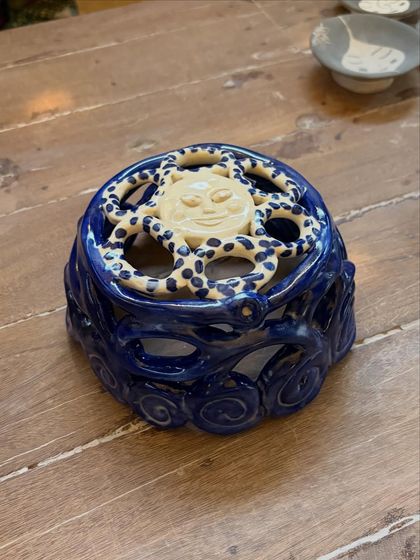 Aarti's whimsical sun-themed incense holder. The combination of the cheerful sun, the dotted pattern, and the deep blue glaze is just delightful.