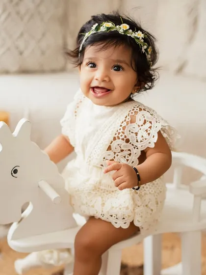 A happy baby on a toy rocking horse. Using age-appropriate props helps to engage children and capture their playful personalities during a milestone session.