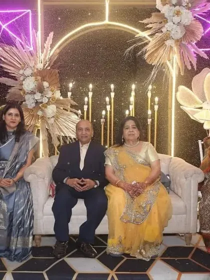A beautiful family portrait at a 50th Golden Wedding Anniversary celebration I planned. The backdrop features a sequin wall, neon lights, and elegant pampas grass arrangements.
