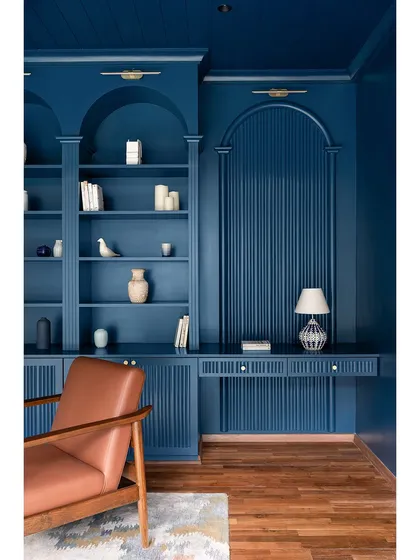 A detail of the library's built-in desk and shelving, featuring fluted paneling and a cohesive monochromatic color scheme. This space proves that a home office can be both highly functional and incredibly stylish.