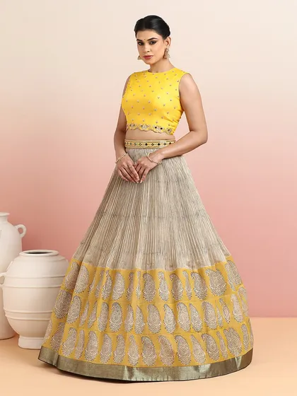 The full view of the yellow blouse with the beige paisley lehenga, a soft and elegant option for daytime events.