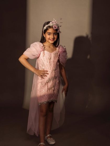 A confident pose in our pink tail dress, showing off the pearl details and lace trim.
