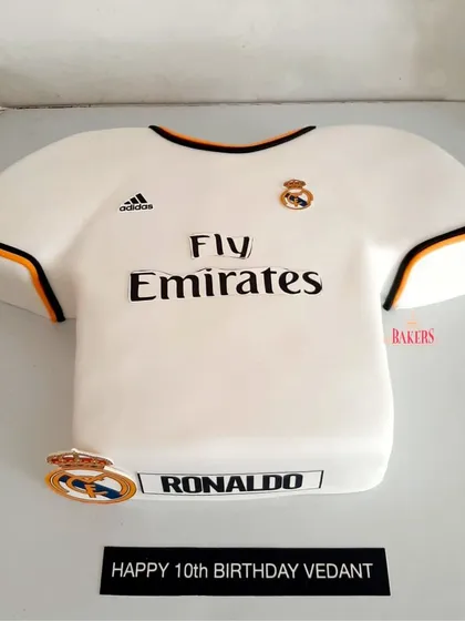 A custom Real Madrid jersey cake for a young football fan's 10th birthday. I handcrafted this cake to look just like Ronaldo's iconic jersey, complete with the logos and sponsors. It's a dream come true for any fan.