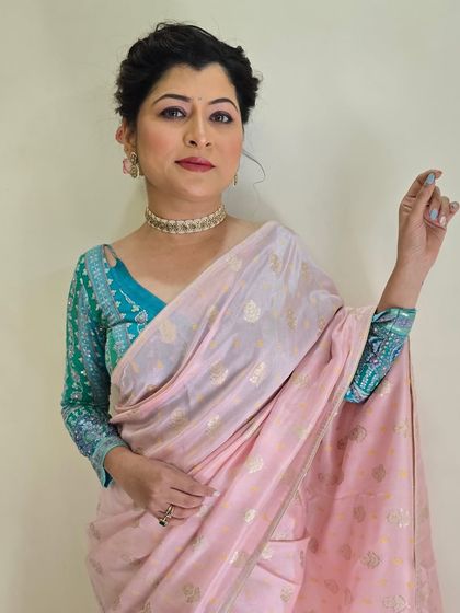 A full-view portrait showcasing the beautiful saree and blouse. The makeup is polished and perfect for a formal event.