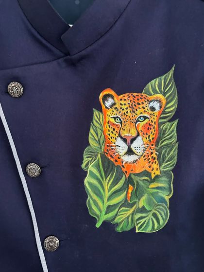 The finished leopard painting shown on the collar and chest area of the jacket. The placement makes it a prominent and stylish feature, contrasting beautifully with the dark fabric and silver buttons.