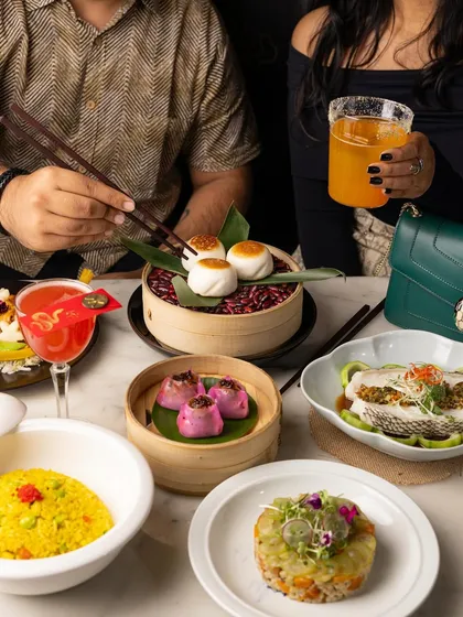 A candid shot of a couple enjoying a Pan-Asian meal. Including people in the frame creates a relatable dining scene and helps restaurants showcase the atmosphere of their establishment.