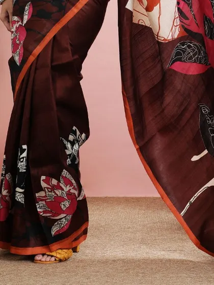A detailed shot of the lower part of the saree, showing the beautiful print and the orange border.