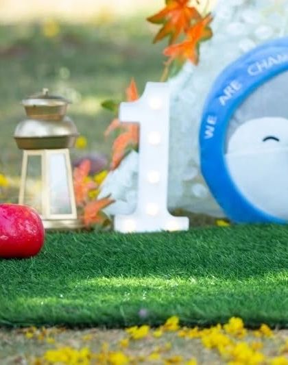 A close-up of the details from a first birthday setup. I carefully arrange props like the light-up number '1' and colorful toys to create a festive scene.