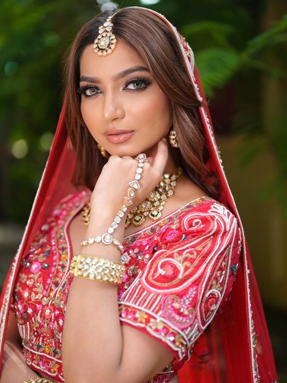 A complete bridal look featuring a heavy, gold-plated Kundan necklace, haath phool, and maang tikka, all available for rent.