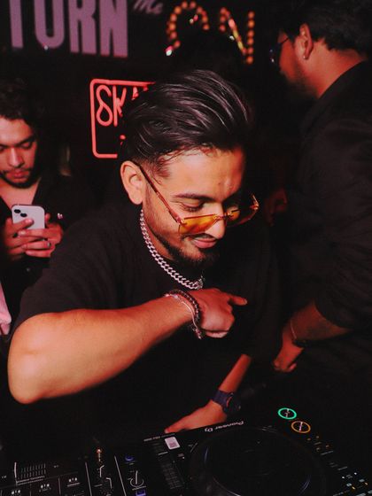 A candid shot of me at the DJ console, focused on the next track. I am constantly curating the music live to match the energy of the dance floor.